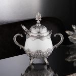 A Silver and White Sugar Serving Bowl